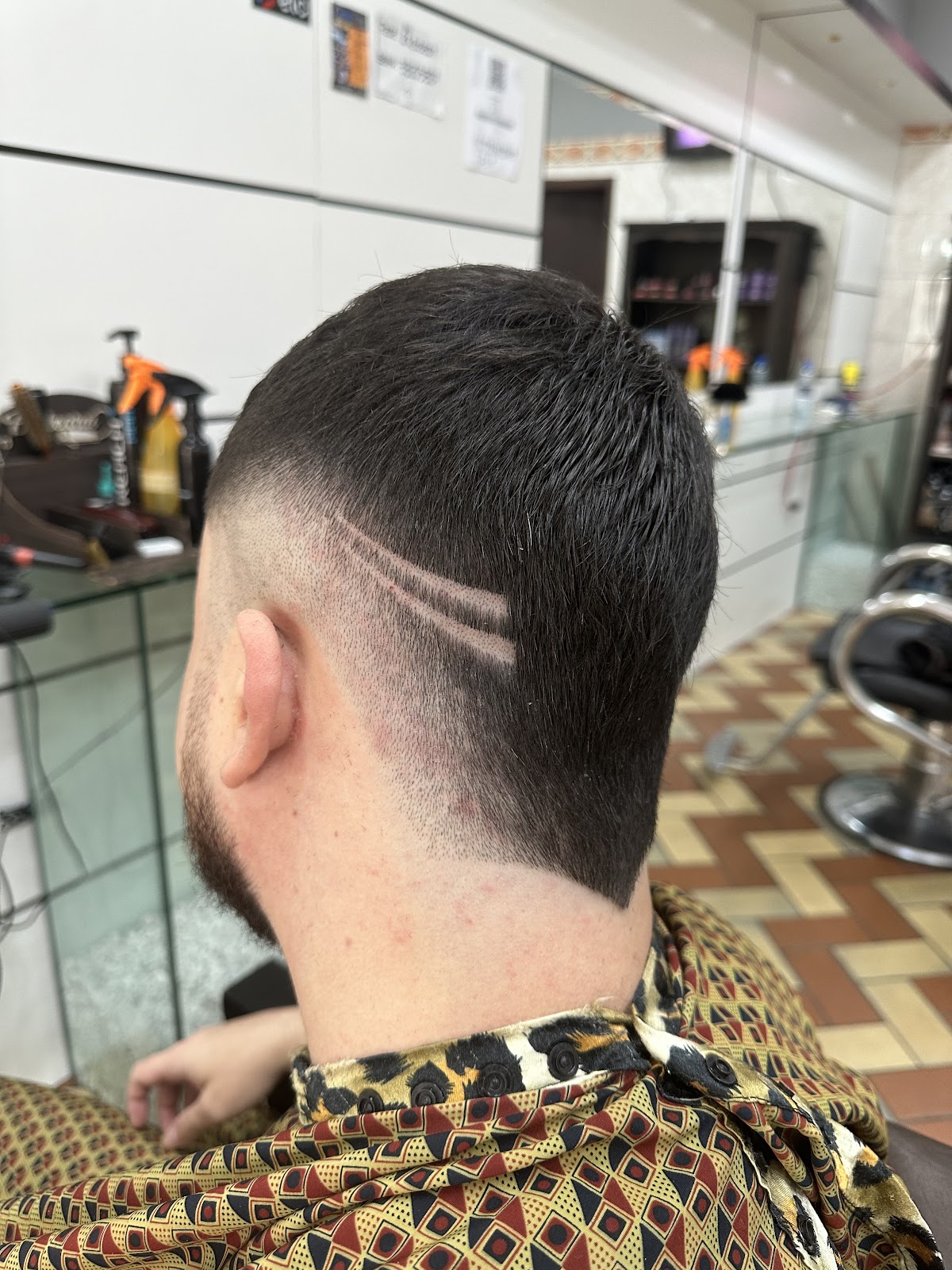 Corte com risco desenhado na nuca, feito na Barbearia André