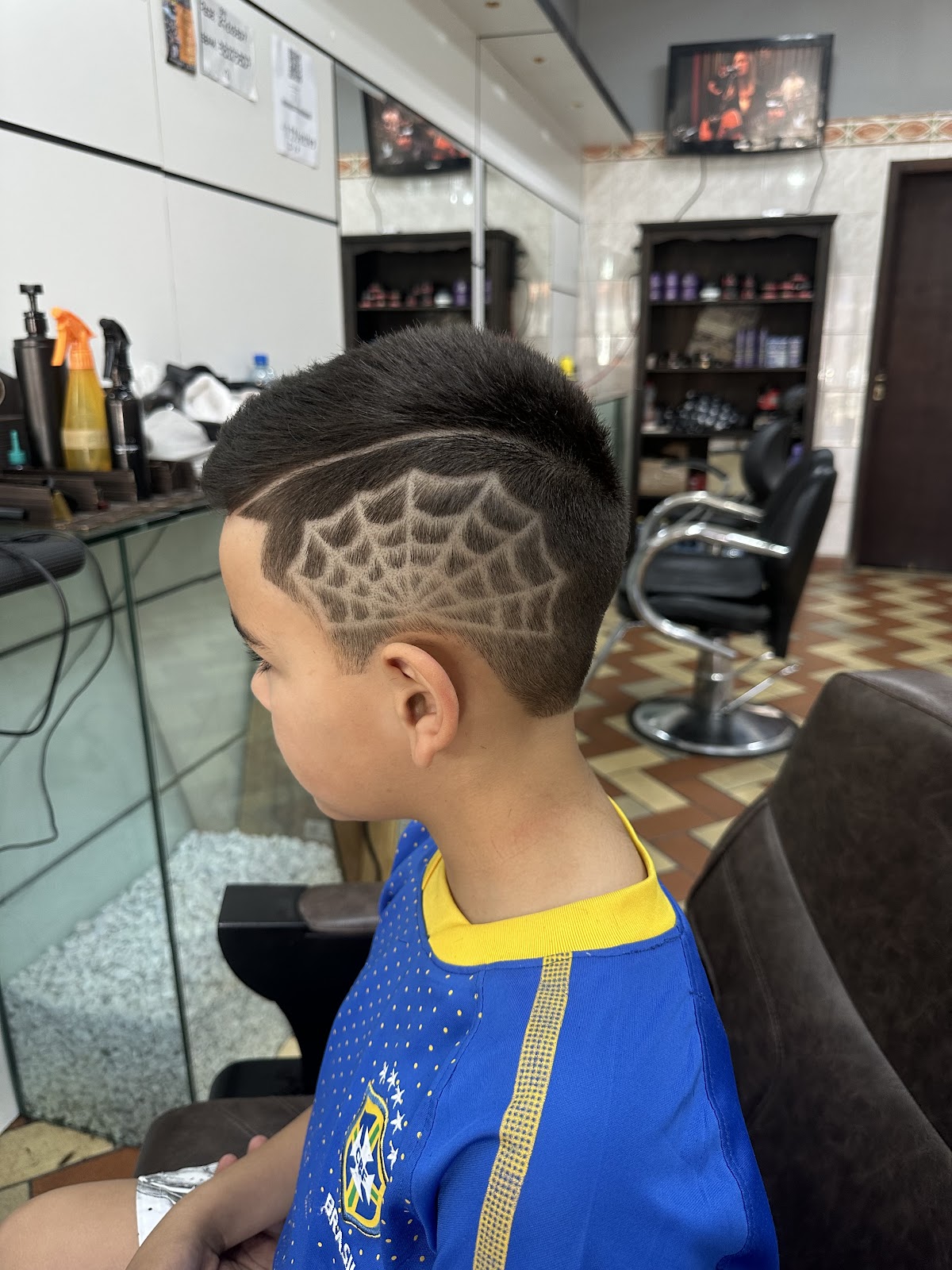 Corte infantil com desenho de teia de aranha, feito na Barbearia André